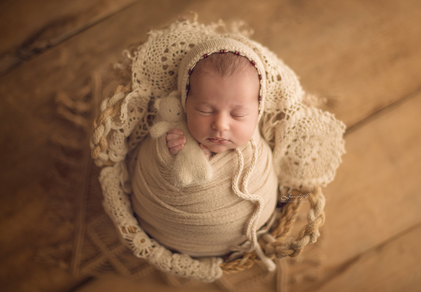 Bebe ține jucăria în timp ce doarme la ședința de nou născut